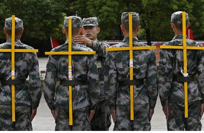 Tân binh Trung Quốc huấn luyện điều lệnh đội ngũ phải đeo giá chữ thập giữ cho lưng thẳng.