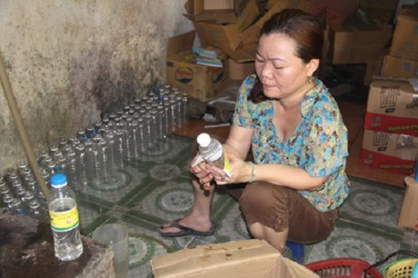 Bà Kim thực hiện lại việc pha “giấm ăn” bằng axit và nước lã.