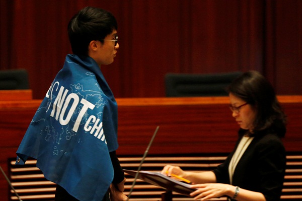 Tân nghị sĩ Baggio Leung khoác lên mình tấm banner phản đối Trung Quốc - Ảnh: Reuters 