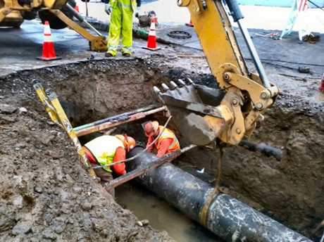 Công nhân sửa chữa đường ống dẫn nước bằng gang bị vỡ ở Oregon, Mỹ.