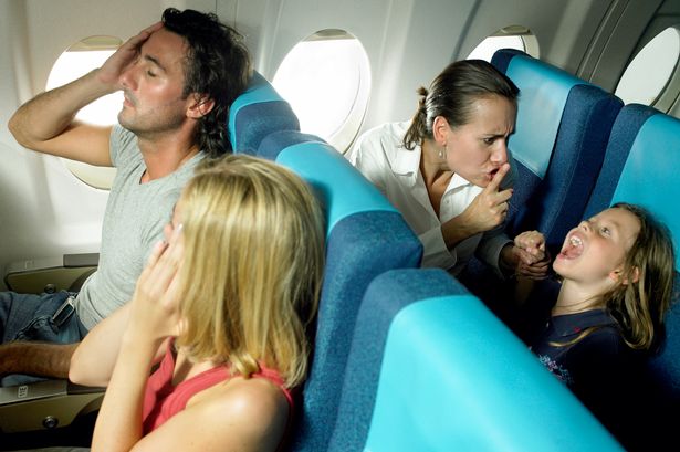 Girl-5-7-yelling-behind-young-couple-in-airplane