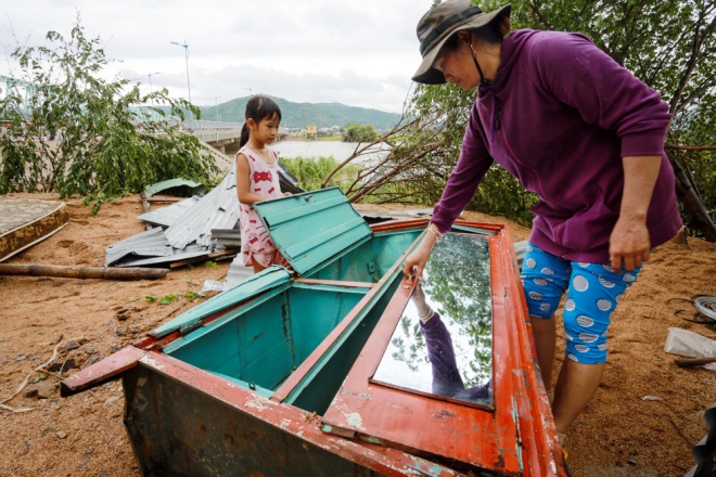 Bà Trần Thị Thảo Trang (thị trấn La Hai, huyện Đồng Xuân) lục tìm những đồ vật trong chiếc tủ của gia đình bị nước lũ cuốn trôi.