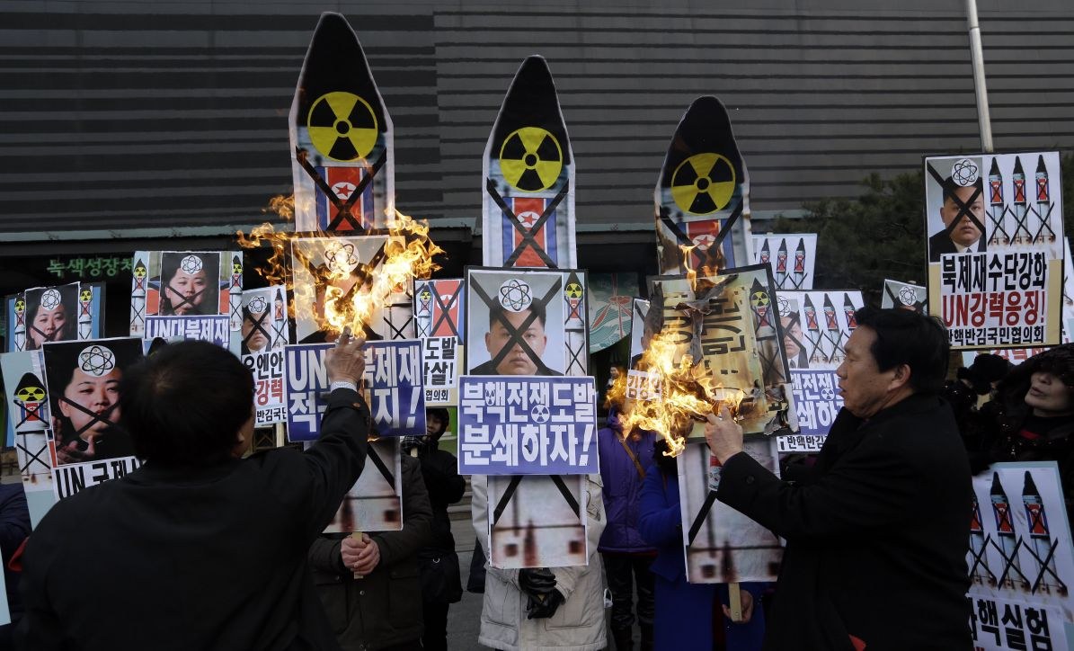 South Korean protesters burn the pictures of North Korean leader Kim Jong Un during an anti-North Korea rally following a nuclear test conducted by North Korea, in Seoul, South Korea, Tuesday, Feb. 12, 2013. North Korea apparently conducted a widely anticipated nuclear test Tuesday, strongly indicated by an "explosion-like" earthquake that monitoring agencies around the globe said appeared to be unnatural. The letters read " Support, U.N. sanction strongly and Out, Kim Jong Un." (AP Photo/Lee Jin-man)