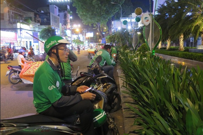 Anh Thái chạy Grab bike đón khách trước tòa nhà Viettel đường Cách Mạng Tháng Tám. 