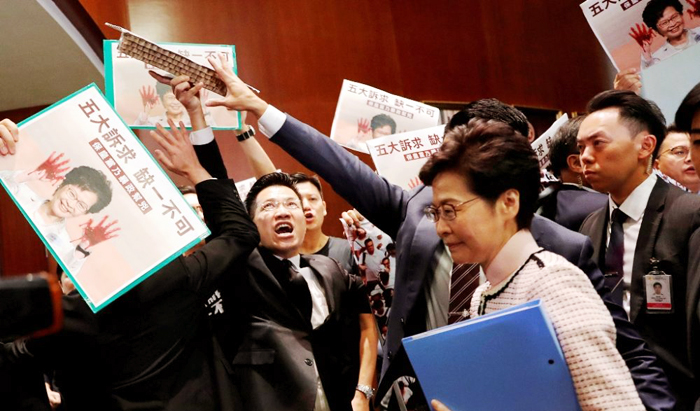 Các nghị viên đối lập ở Hồng Kông đưa hình Trưởng Đặc Khu Carrie Lam với đôi tay “vấy máu” trong nghị trường. 