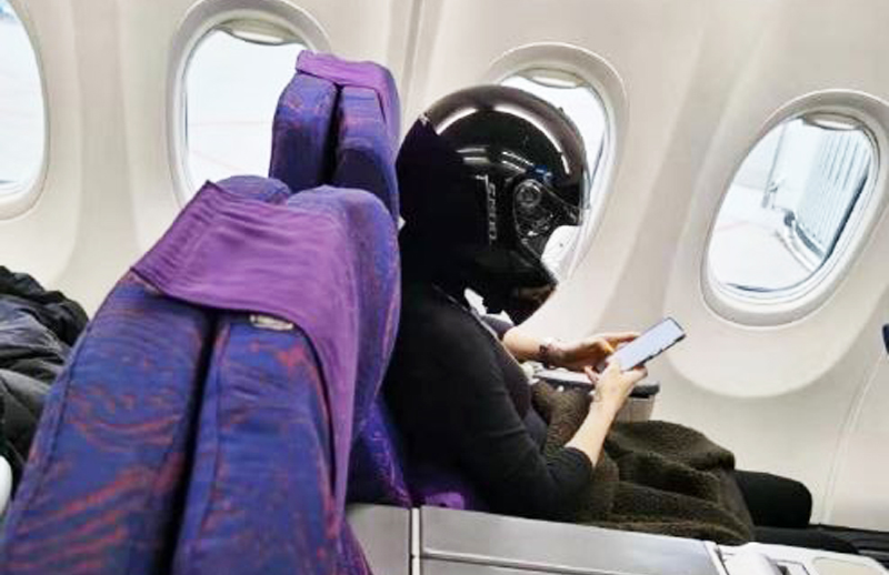 Một du khách Trung Quốc khá "cẩn trọng" khi ngồi trên máy bay còn đội nón bảo hiểm che kín toàn bộ phần đầu. 