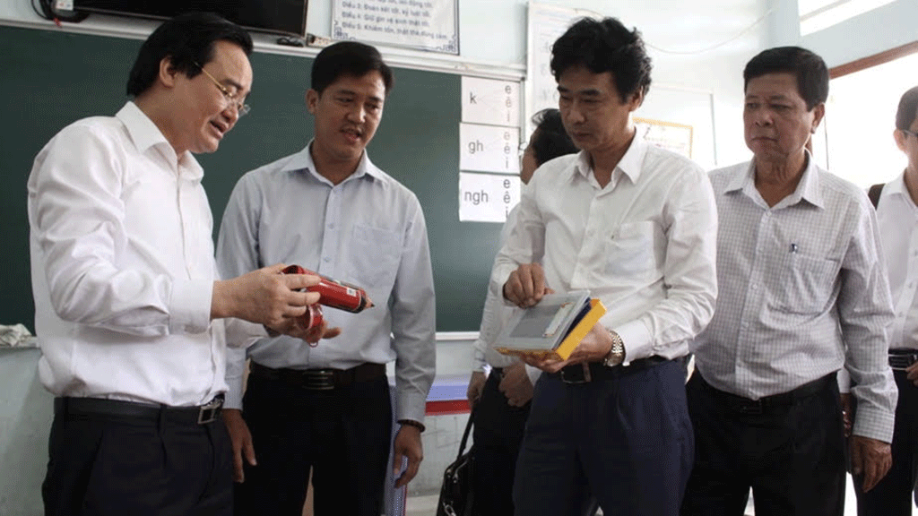 Ông Phùng Xuân Nhạ (bìa trái) kiểm tra công tác phòng ngừa dịch bệnh ở trường học tại Đồng Tháp sáng 14/2. (Ảnh qua thanhnien)