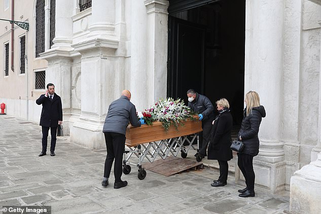 Một cỗ quan tài được đưa ra khỏi bệnh viện trước sự chứng kiến ​​của hai người thân và một nhân viên nhà tang lễ ở Venice
