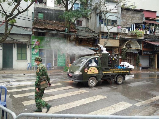 Lực lượng quân đội tiến hành phun thuốc khử trùng tại một số tuyến phố trên địa bàn phường Trúc Bạch. (Ảnh qua Plo)