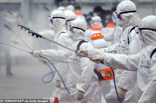 Hình ảnh các binh sĩ Hàn Quốc mặc trang phục bảo hộ đang phun thuốc khử trùng nhằm phòng ngừa chống lại sự lây lan của virus gây ra căn bệnh COVID-19  tại nhà ga đường sắt Dongdaegu, thành phố Daegu ngày 29/2.