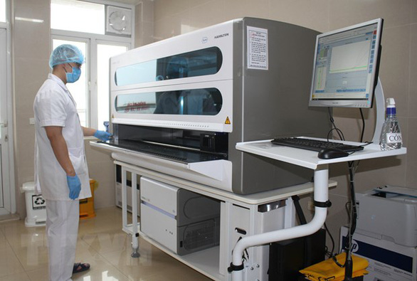 Cán bộ y tế xét nghiệm mẫu trên máy xét nghiệm Realtime PCR. (Ảnh qua tuoitre)