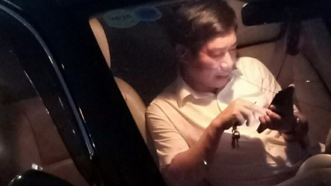 Hình ảnh ông Nguyễn Văn Điều ngồi bấm điện thoại sau khi lái xe gây tai nạn vào tối 8/5. (Ảnh qua thanhnien)