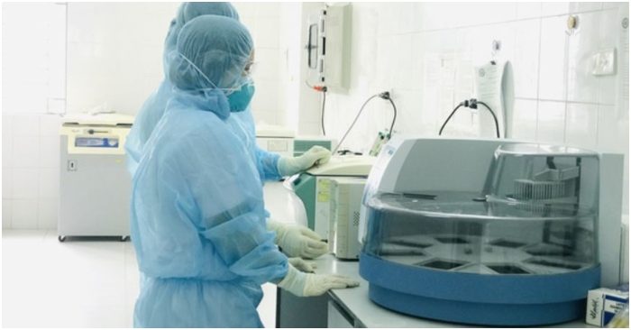 Cán bộ Trung tâm Kiểm soát bệnh tật tỉnh Thanh Hóa vận hành máy xét nghiệm virus Vũ Hán. (Ảnh qua tuoitre)